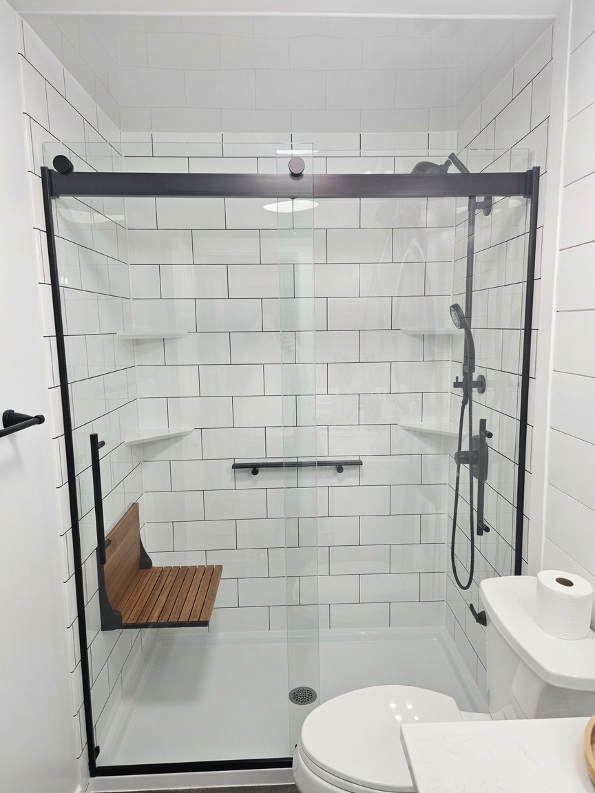 Walk-in shower with subway tile, folding seat, grab bars, and matte black hardware