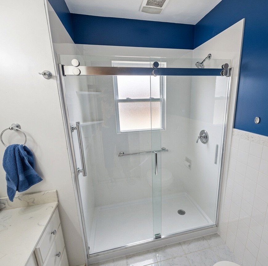 Walk-in shower with white walls, frosted window, grab bar, and blue painted room