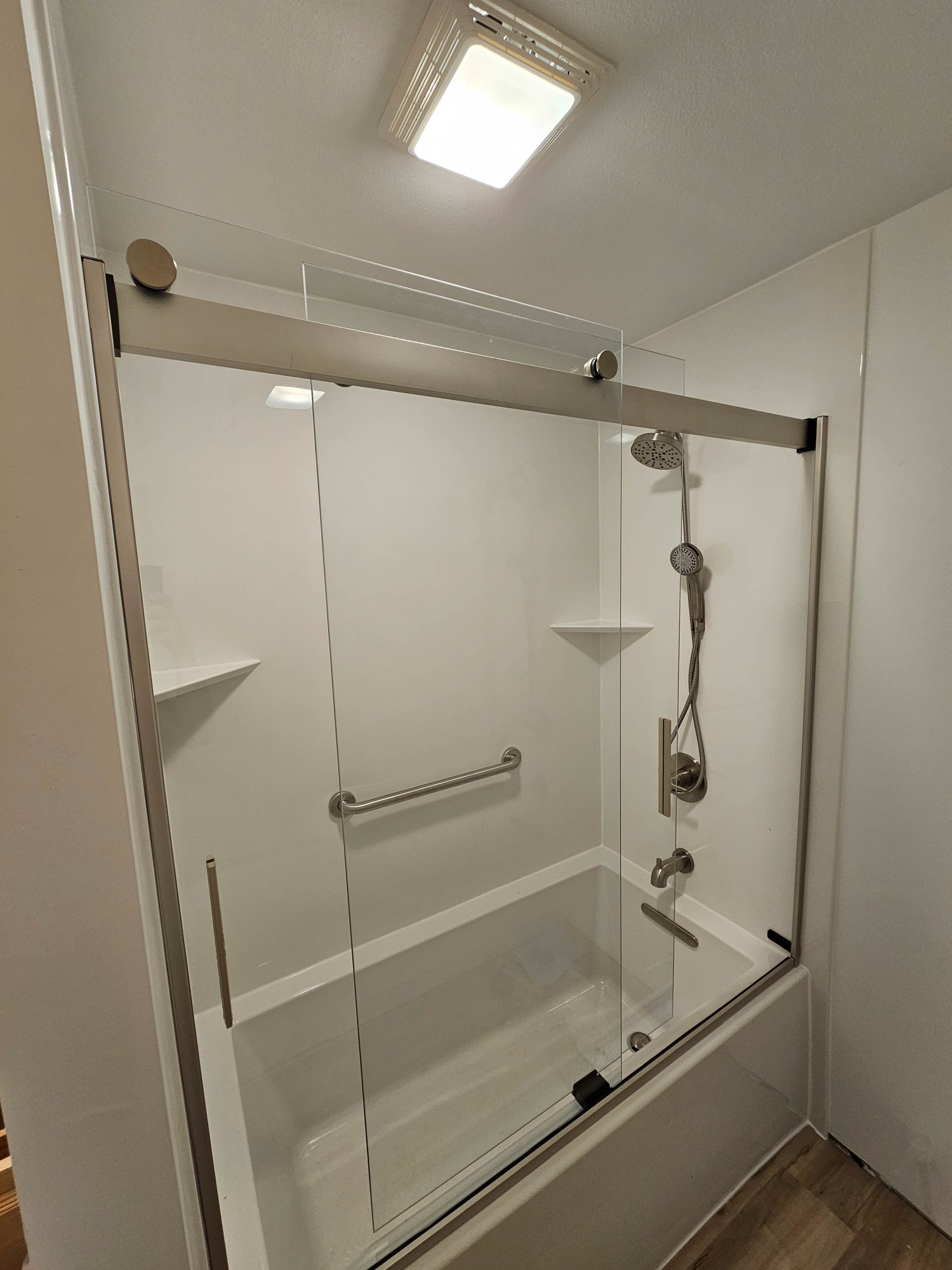 Marble-look shower with teak seat and brushed metal hardware